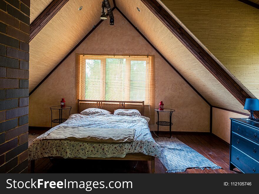 Interior of a room with a bed on the top floor of a wooden house