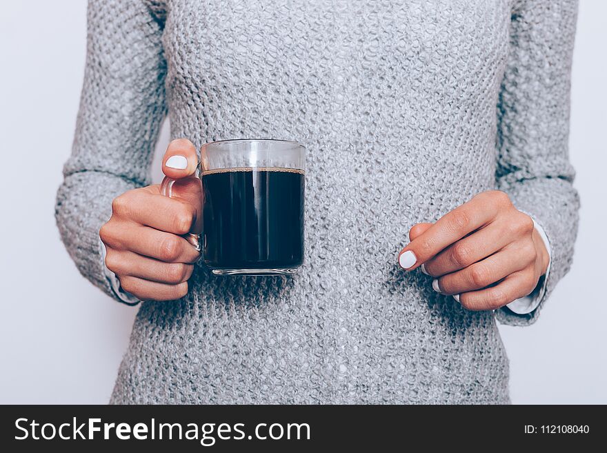 Transparent coffee cup in female hands with white manicure close-up