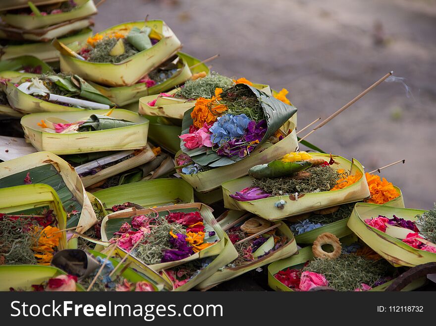 Colorful exotic flowers and incenses stacked. Hindu God& x27;s offerings in Balinese tradition. Colorful exotic flowers and incenses stacked. Hindu God& x27;s offerings in Balinese tradition