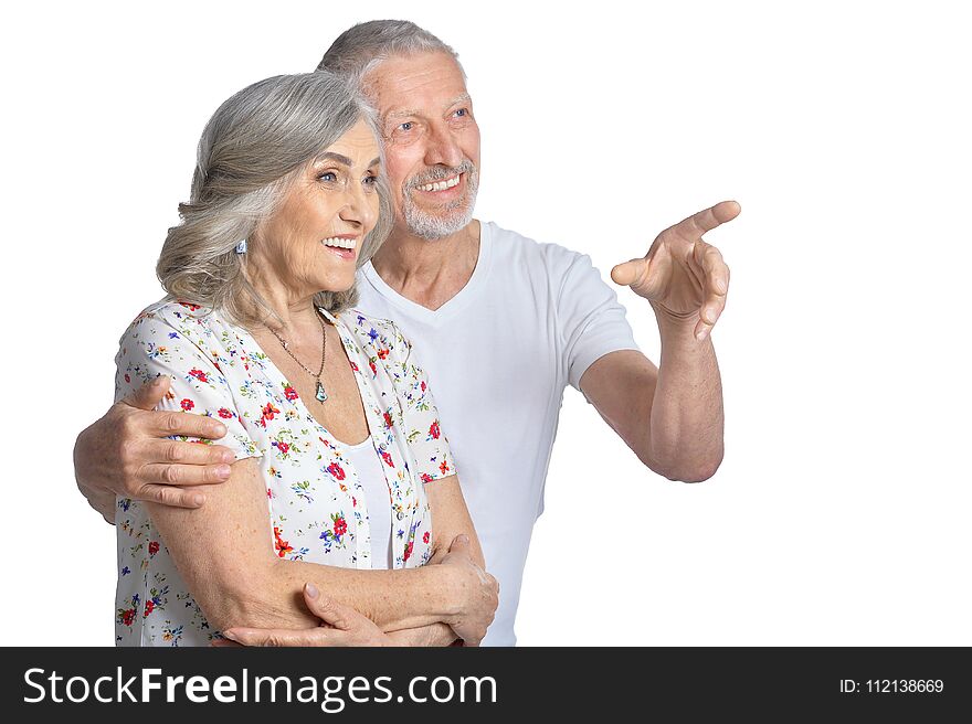 Portrait of hugging senior couple pointing isolated on white background