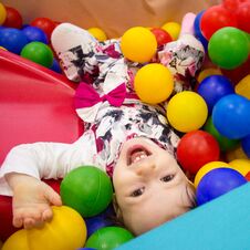 Little Cute Smile Girl Plays In Balls For A Dry Pool. Play Room. Happiness Stock Images