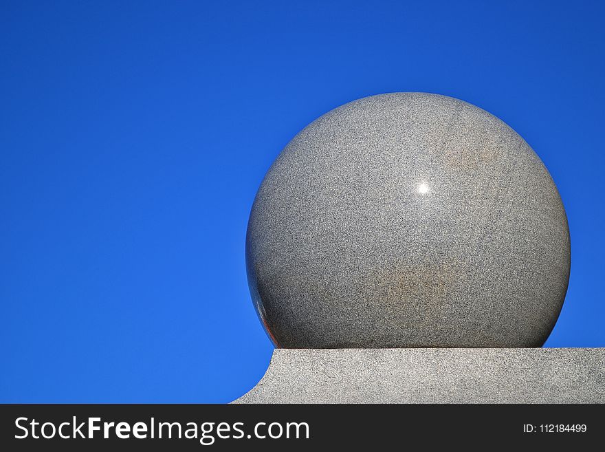 Gray Ball on Gray Surface With Blue Background