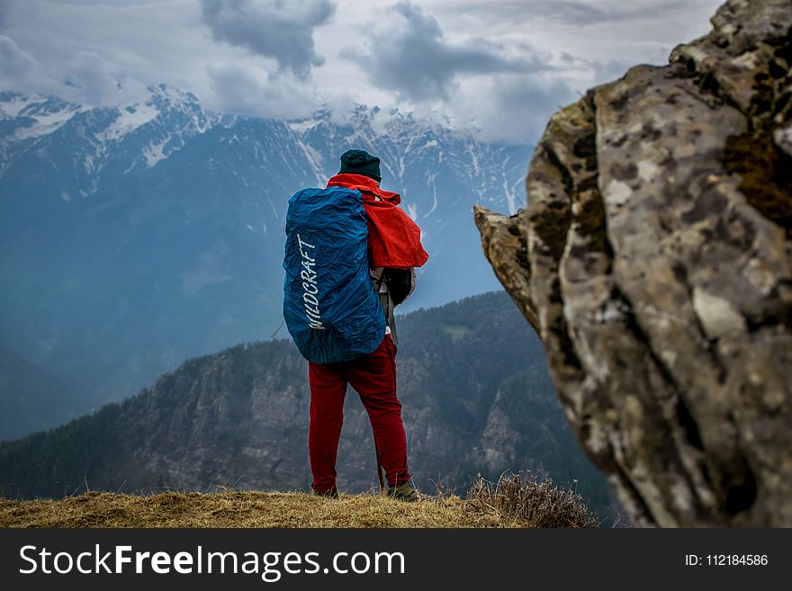 Man Wearing Red Pants on Cliff