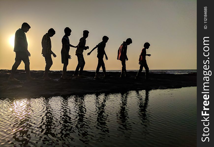 Group of Children Walking Near Body of Water Silhouette Photography