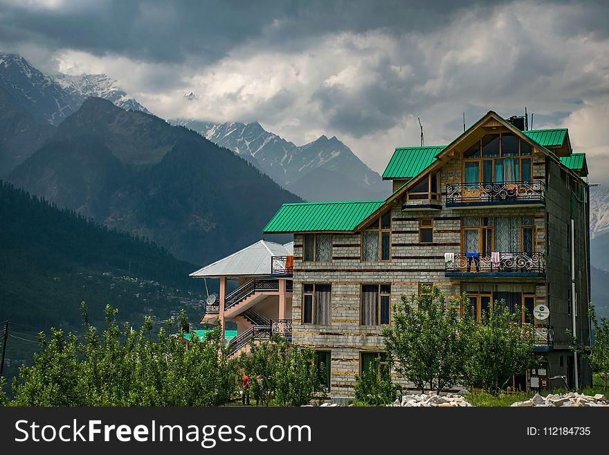 Brown And Green Concrete Building Near Mountains At Daytime