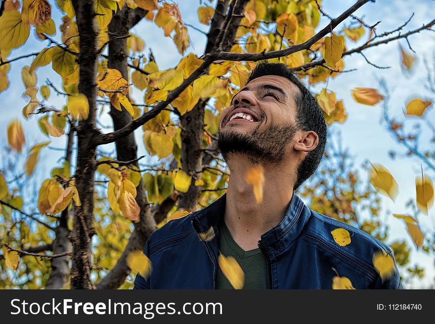 Man With Blue Denim Zip-up Jacket Near Yellow Leaf Tree