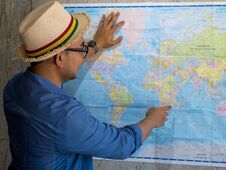 Tourist Pointing At Worldmap For Next Destination, Lifestyle Con Royalty Free Stock Images