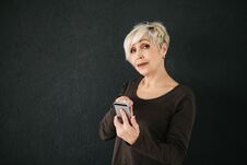 A Positive Modern Elderly Woman Is Holding A Cell Phone And Is Using It. The Older Generation And Modern Technology. Stock Image