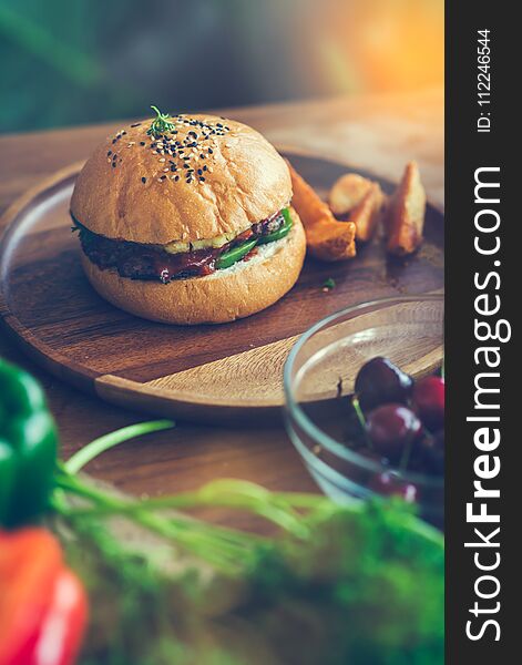 Meat burger on wooden plate with vegetable