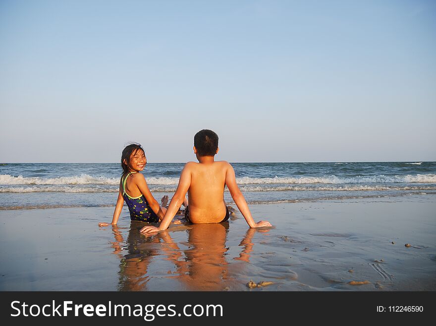 Happy Children Sitting On Hua Hin Beach In Sunny Day