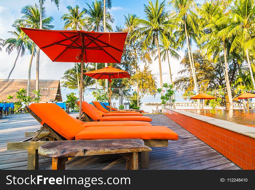 Umbrella and chair around swimming pool in hotel and resort - Holiday Vacation concept