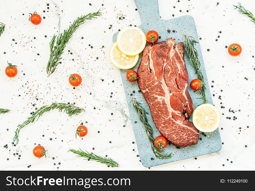 Raw beef meat on cutting board with vegetable and ingredient for cooking