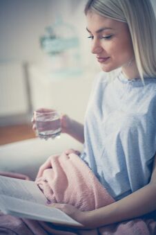 Young Woman Reading Book , Enjoy In Living Room. Royalty Free Stock Image