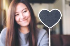 Asian Woman Holding A Blank Heart Shape Blackboard Sign With Feeling Happy And In Love Royalty Free Stock Images