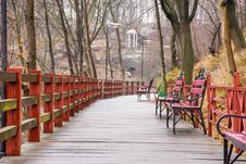 Wooden Path - Hinged Bridge With Wet Boards, Wrought Iron Benches And Lanterns In The Park On A Hillside Overlooking The White Rot Stock Photo