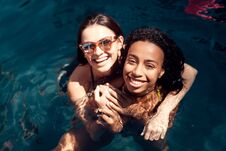 Two Young Girls In Swimsuits Have Fun In Swimming Pool At Summer Time. Stock Photo Two Young Girls In Swimsuits Have Fun In Swimming Pool At Summer Time. Stock Photo