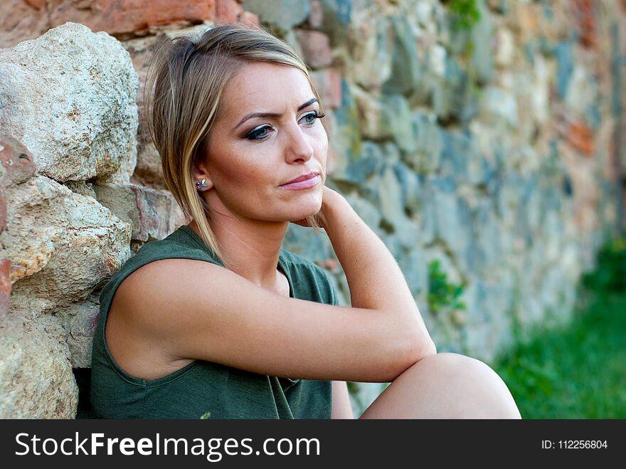 Outdoor portrait of a sad, moody or depressed, beautiful blonde woman. Outdoor portrait of a sad, moody or depressed, beautiful blonde woman