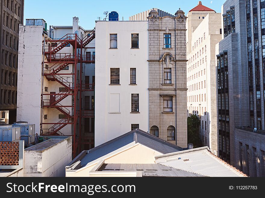 Rooftops and the back of buildings on a street in the downtown district of a city on a sunny day. Rooftops and the back of buildings on a street in the downtown district of a city on a sunny day