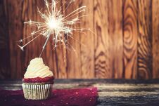 Cupcake With Cream Cheese, With Sparkler On Dark Wooden Background. Royalty Free Stock Photography