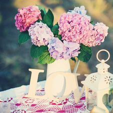 Pretty Bouquet Of Hydrangea Flowers In A Vintage Jar. Flower Decor On The Garden Table. Stock Photo Pretty Bouquet Of Hydrangea Flowers In A Vintage Jar. Flower Decor On The Garden Table. Stock Photo