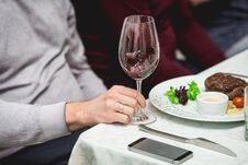 Wine Tasting In A Restaurant. Man Holds Glass Of White Wine. Fresh Grilled Bbq Roast Beef Steak And Sauce On A White Royalty Free Stock Photos