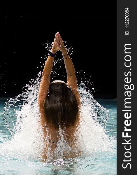 Young Beautiful Woman Making Water Splash At The Pool