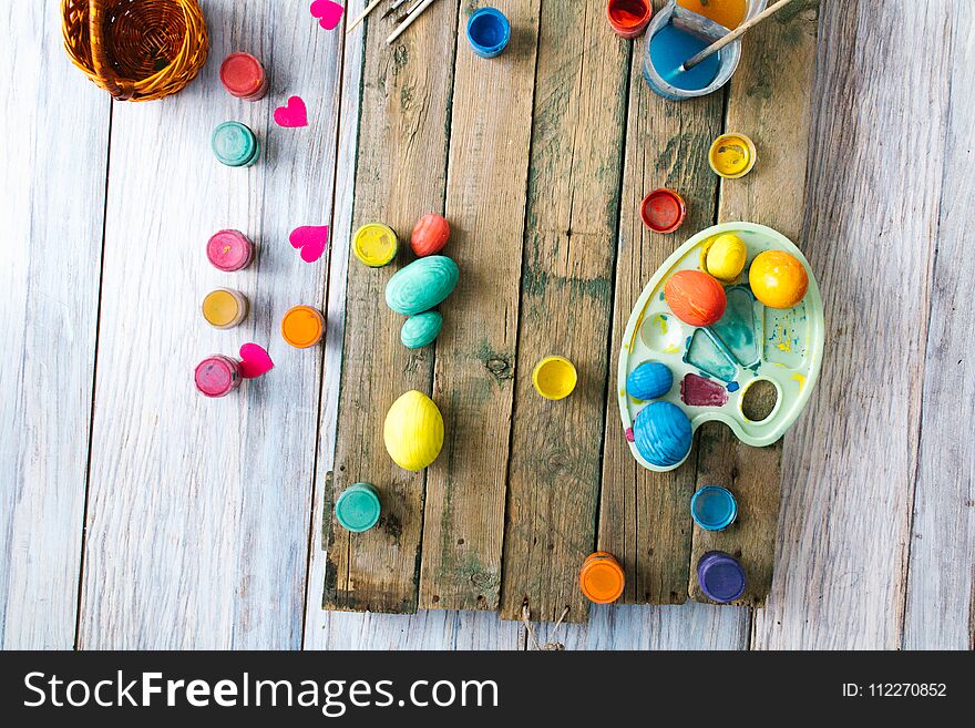 Easter eggs on a wooden background with paints.