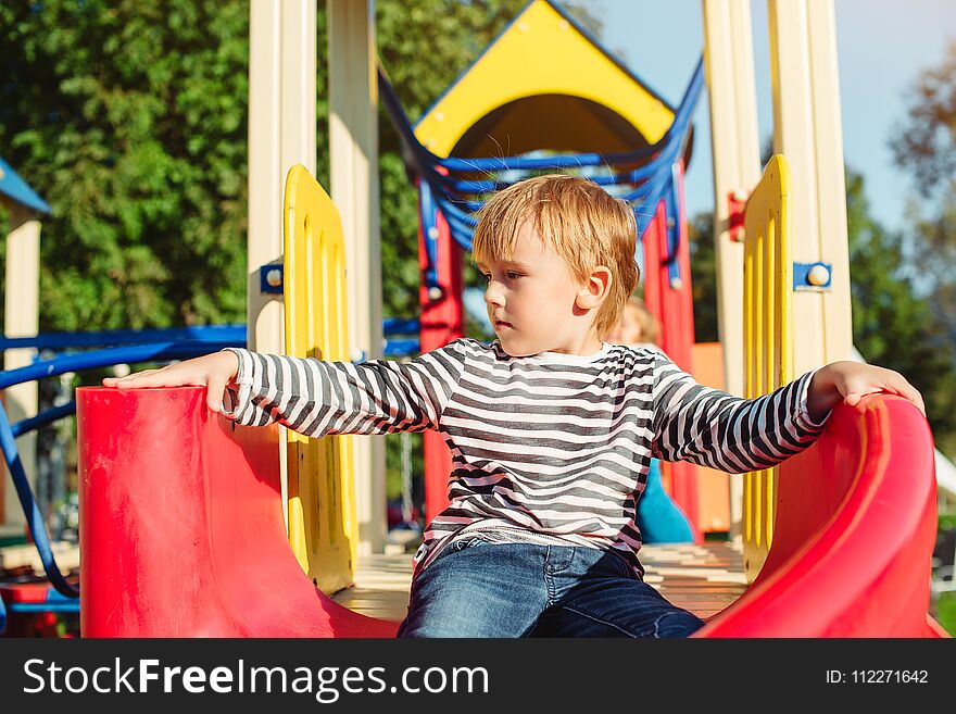 Happy Little Boy On The Playground At Sunny Day.