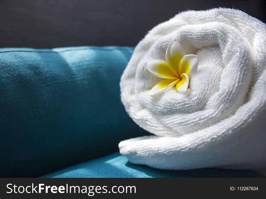 White towel and a flower of Frangipana on a dark background. The concept of SPA. Copy space 1