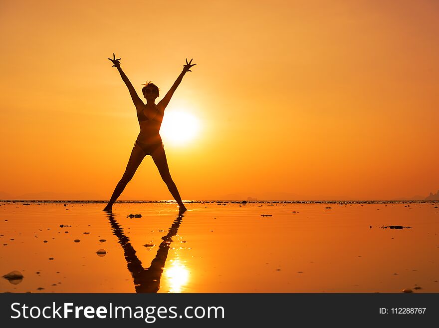 Silhouette Of A Young And Fit Woman On The Beach At Sunset