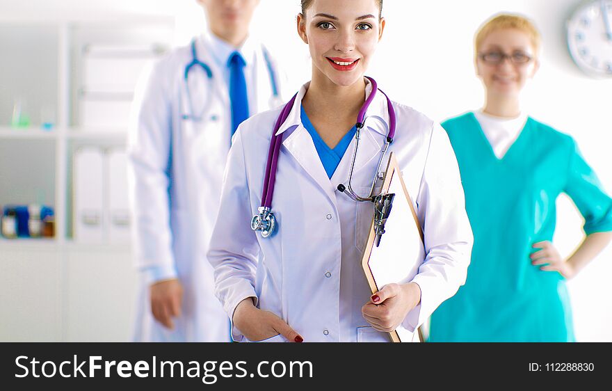 Woman Doctor Standing With Folder At Hospital