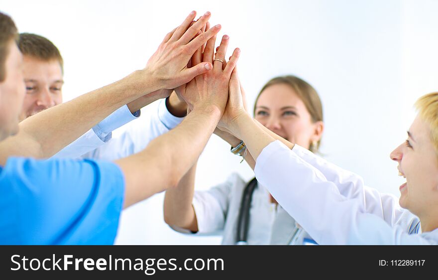 Doctors and nurses in a medical team stacking hands .