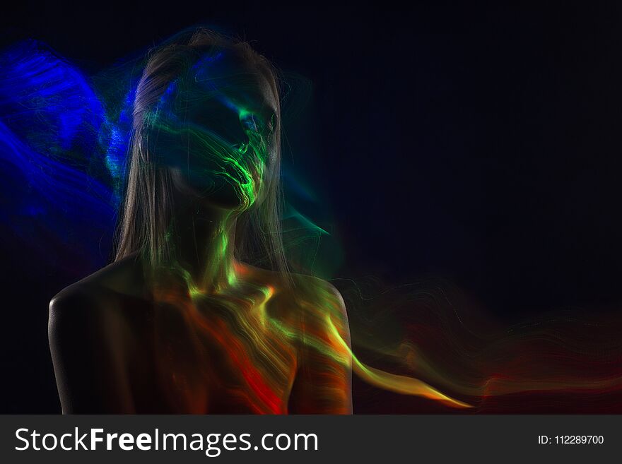 Conceptual avant-garde silhouette portrait of a beautiful blonde girl covered with multicolored lines applied by a lightbrush. Art photo.Copy space. Advertising, fashion and commercial Design