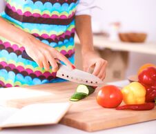 Young Woman Cutting Vegetables In Kitchen Stock Images