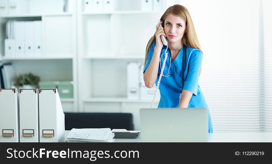 Female Doctor Talking On Phone In Diagnostic Center