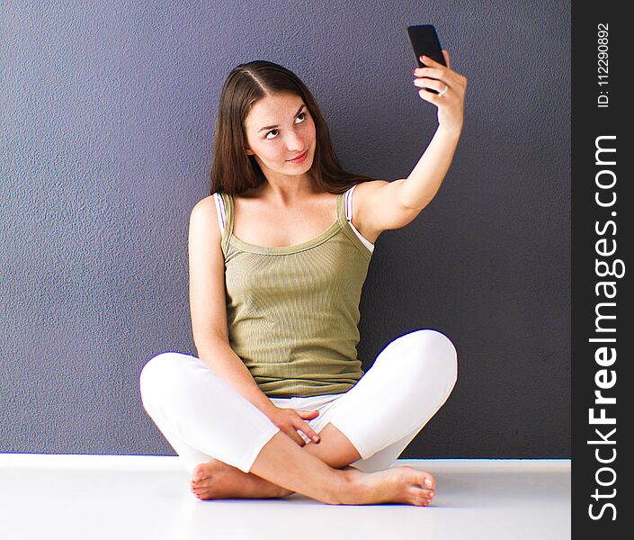Attractive caucasian girl sitting on floor near wall