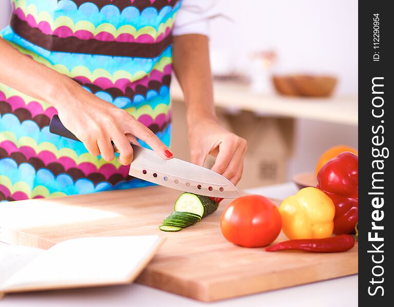 Young Woman Cutting Vegetables In Kitchen