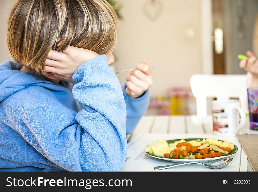 Tired boy does not like to eat his lunch.