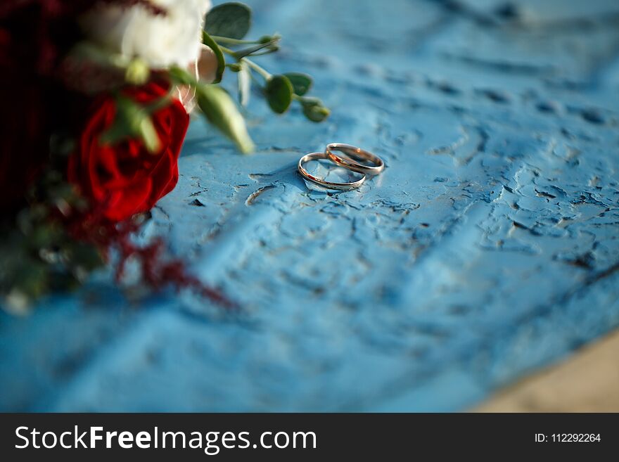 Wedding bouquet with red roses lies on a blue background. Wedding bouquet with red roses lies on a blue background