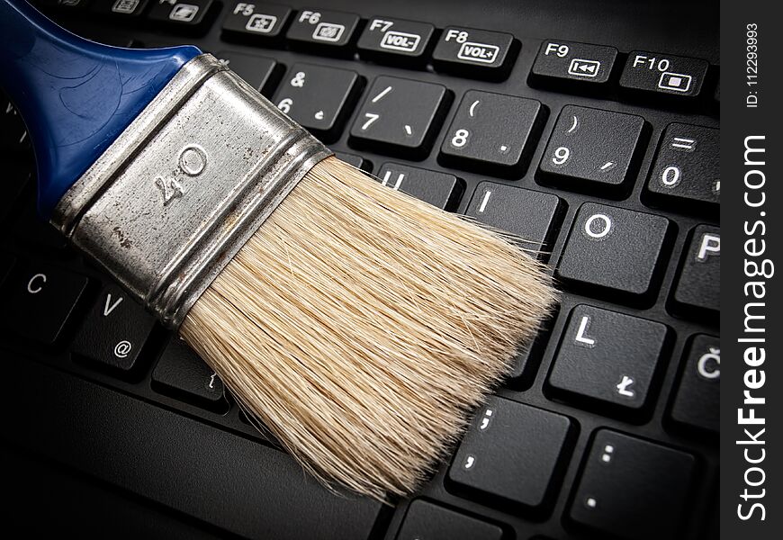 The brush cleans the computer keyboard as a concept of maintaining digital data. The brush cleans the computer keyboard as a concept of maintaining digital data.