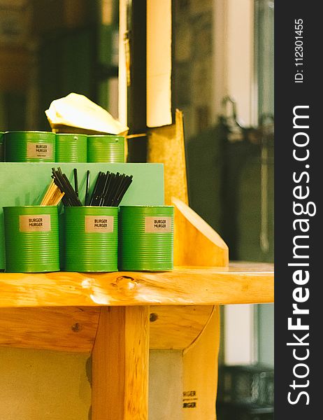 Six Green Tin Can Containers on Table