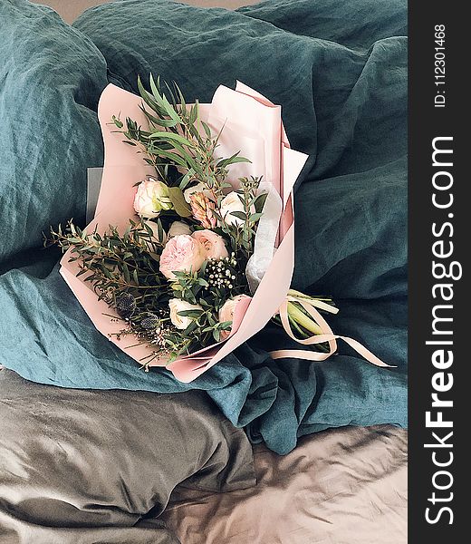 Pink And Green Flower Bouquet On Bed Sheet