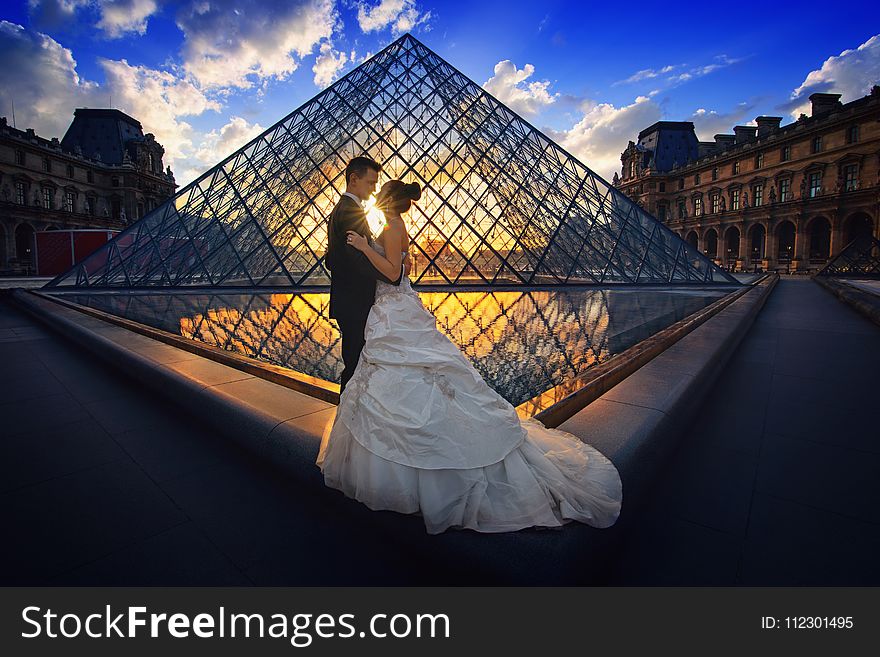 Photography of Man and Woman at the Lourve Museum during Sunset
