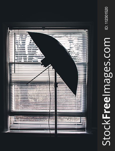 Silhouette Photo Of Studio Umbrella Near White Window Blinds Inside Room