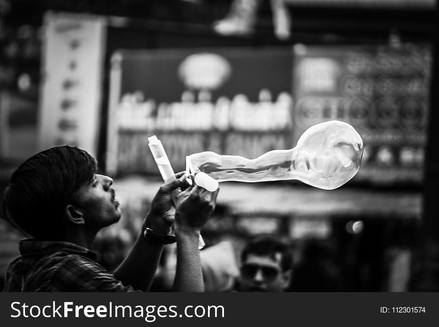 Man Playing Bubbles Grayscale Photo