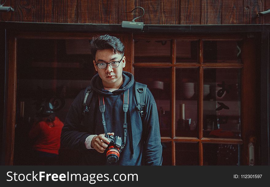 Man Wearing Jacket Holding Dslr Camera