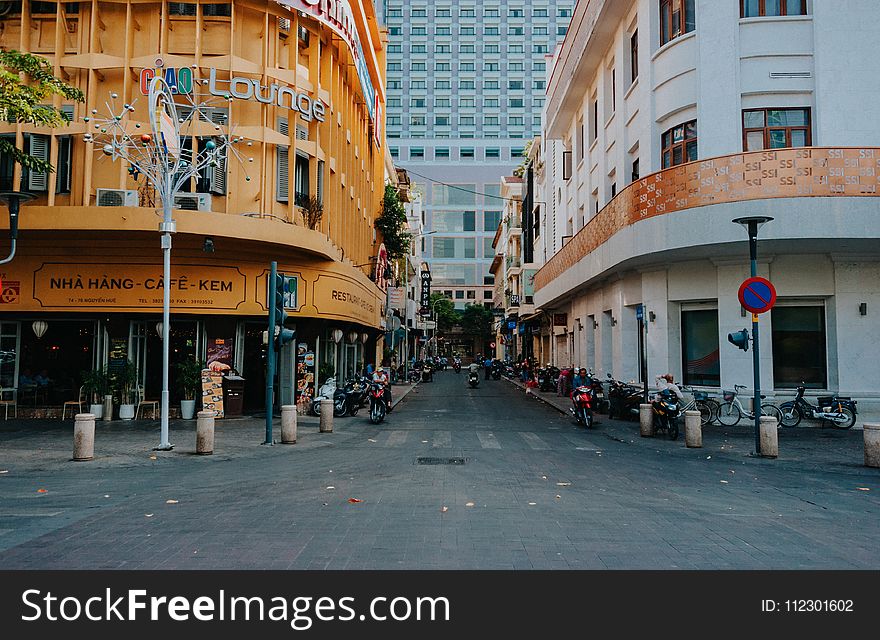 Gray Asphalt Street in Between Yellow and White Concrete Buildings at Daytime