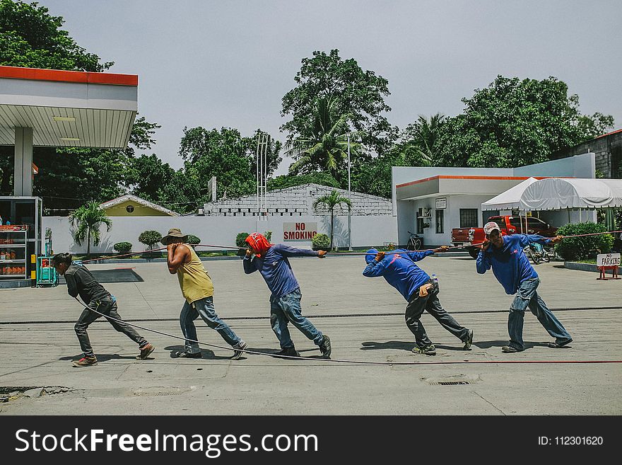 Five Men Pulling Black Rope