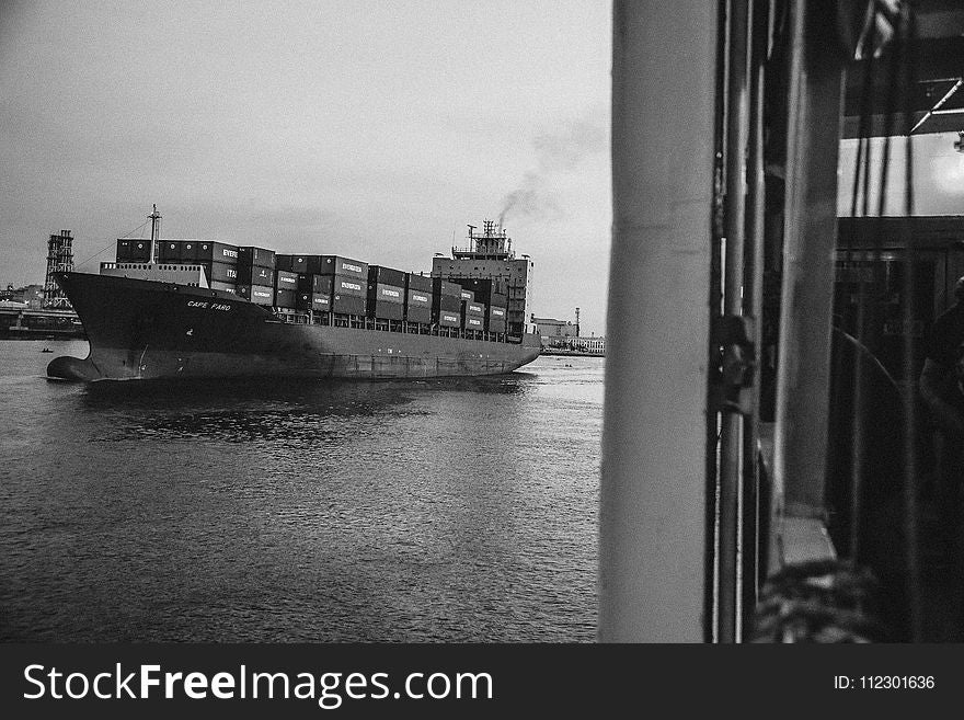 Greyscale Photo of Cargo Ship on Ocean