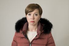 Young Sweet And Sad Red Hair Woman Posing Moody And Depressed Looking To Camera Wearing Warm Winter Coat Jacket With Hood Isolate Stock Photo